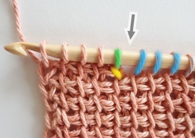 The arrow shows the gap between the short row and the loops left on hook.
