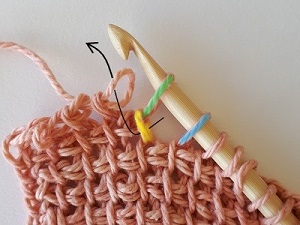 Remove your hook from the active loop (pink), insert it under the first stitch of the short row below (yellow), then insert your hook back in the active loop. 