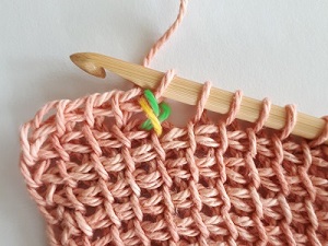 You close 3 loops together (yarn over and pull through 3) to close the crossed stitches.