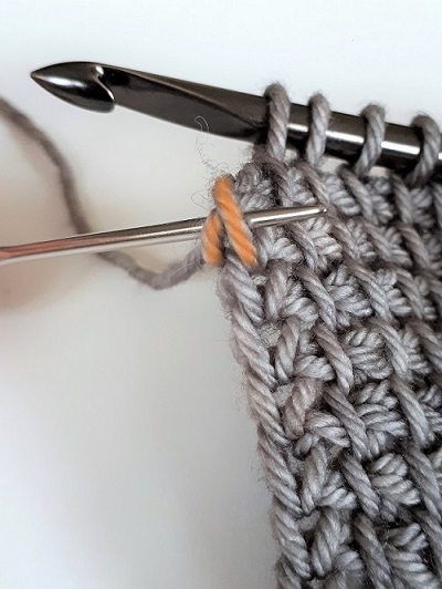 Insert your hook under the 2 strands of yarn on the side of your work. 