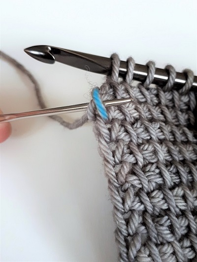 Pick up a loop under the front strand of yarn only (in blue)